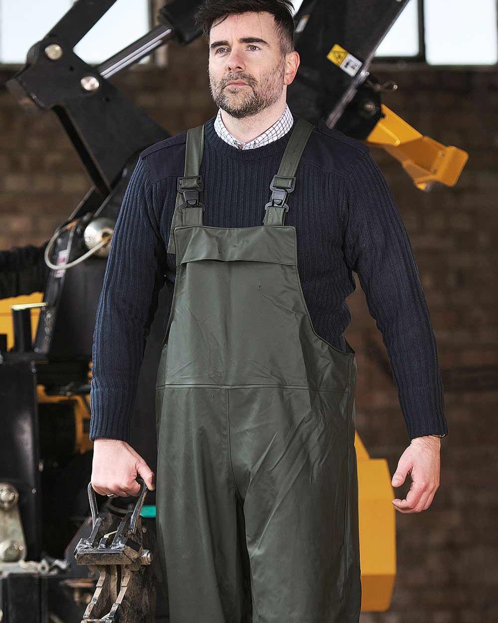 Olive coloured Fort Airflex Waterproof Breathable Bib and Brace Overalls on blurry background