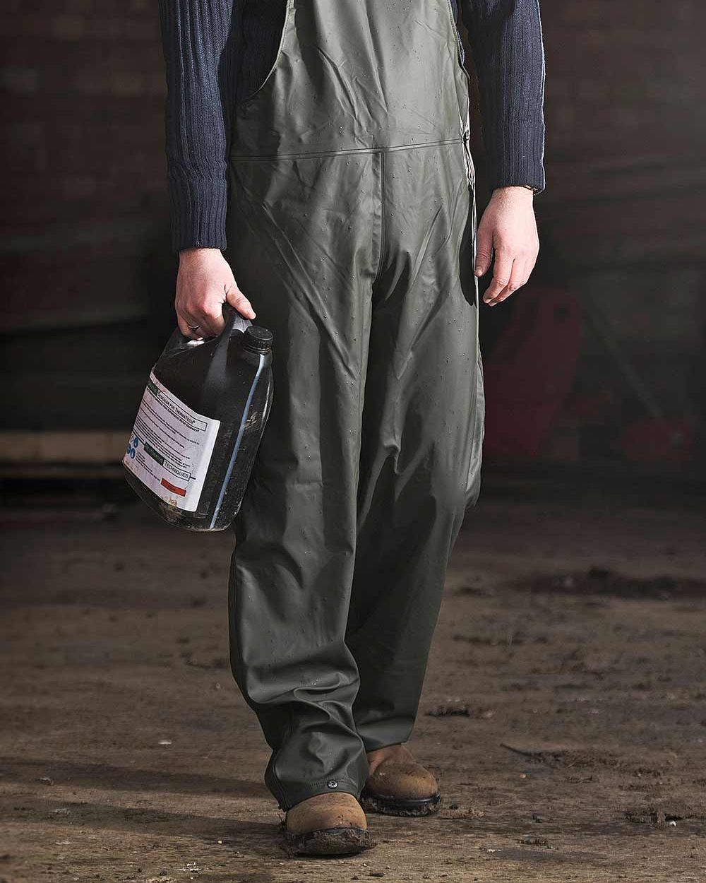 Olive coloured Fort Airflex Waterproof Breathable Bib and Brace Overalls on blurry background