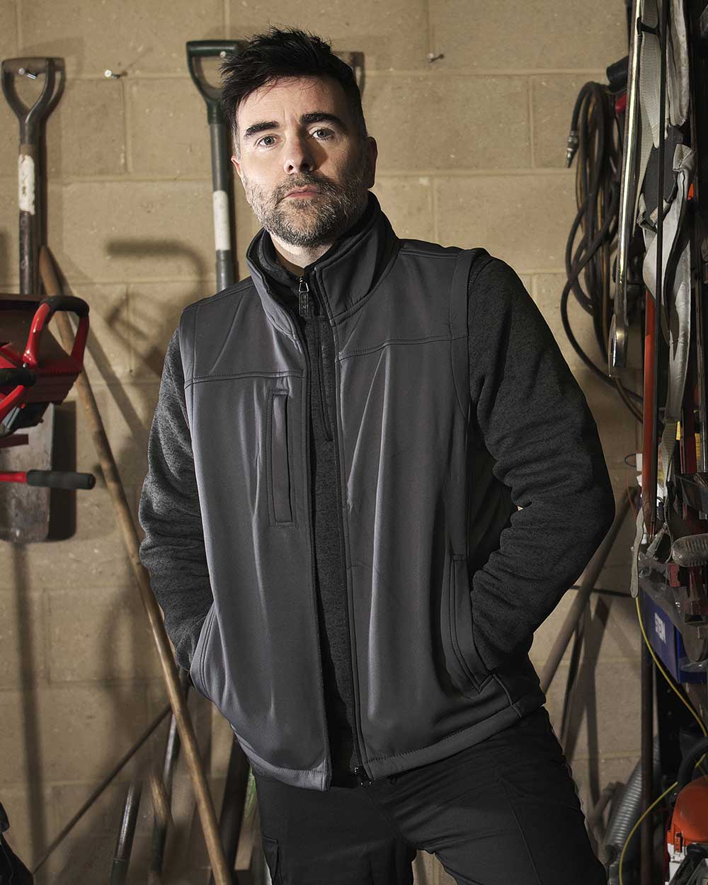 Black coloured Fort Breckland Softshell Bodywarmer on brown background