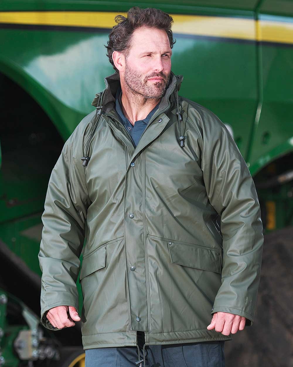 Olive Green coloured Fort Fortex Flex Waterproof Fleece Lined Jacket on blurry background