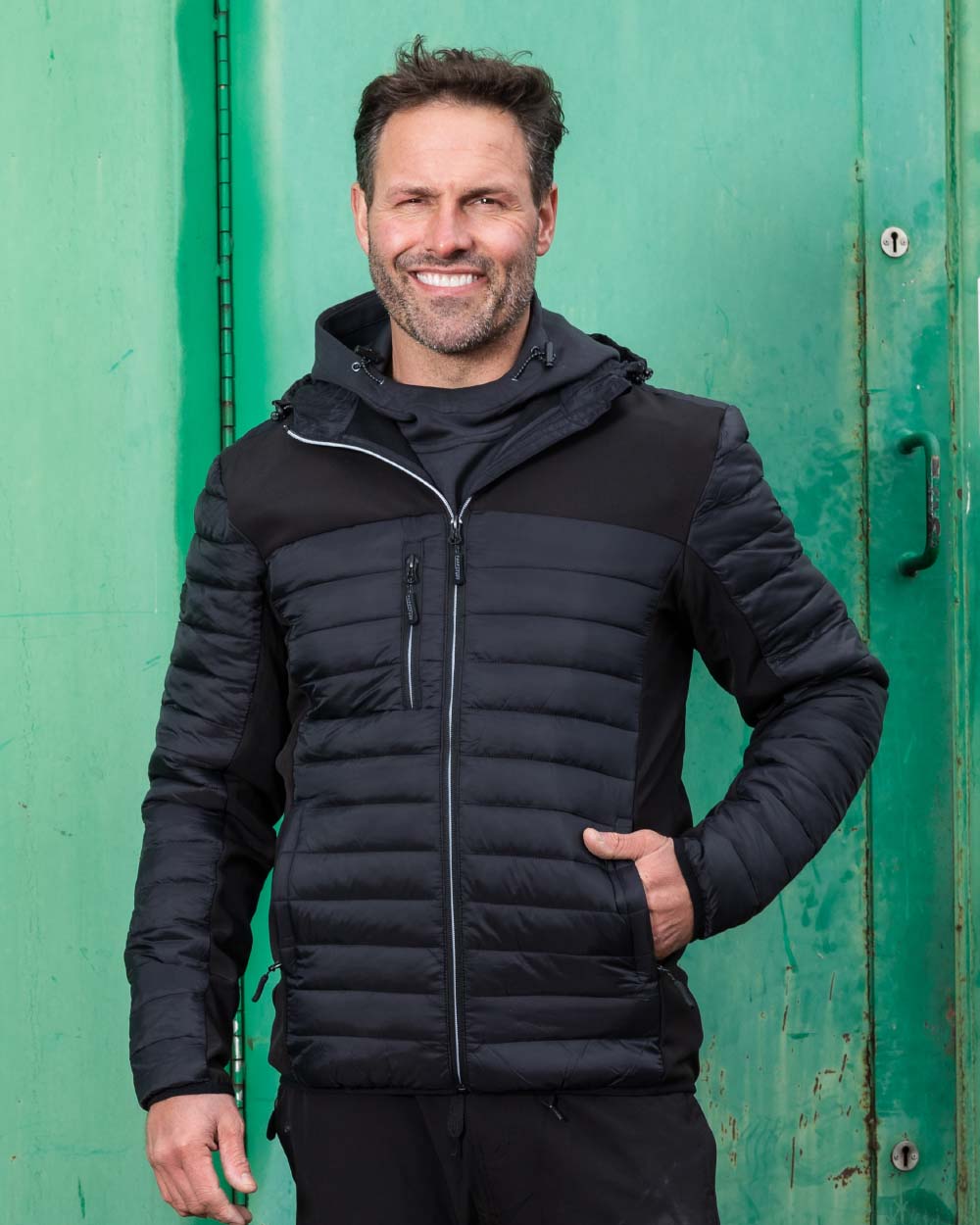 Black Coloured TuffStuff Hatton Soft Shell Jacket On A Warehouse Background