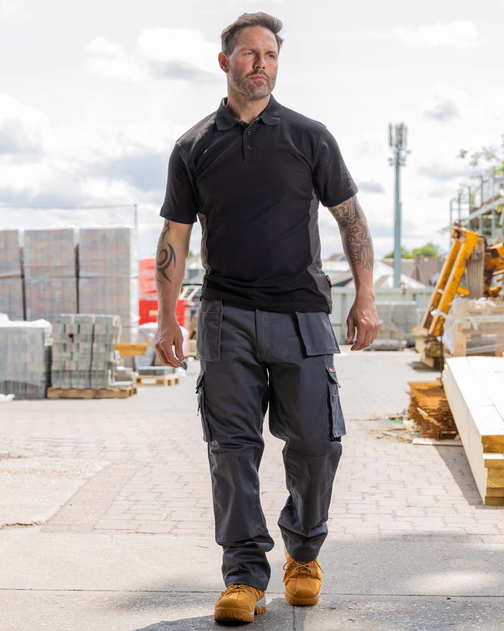 Grey Coloured TuffStuff Pro Work Trousers On A Warehouse Background