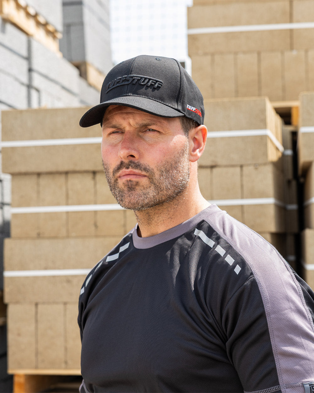 Black coloured TuffStuff Baseball Cap on Model with Construction background