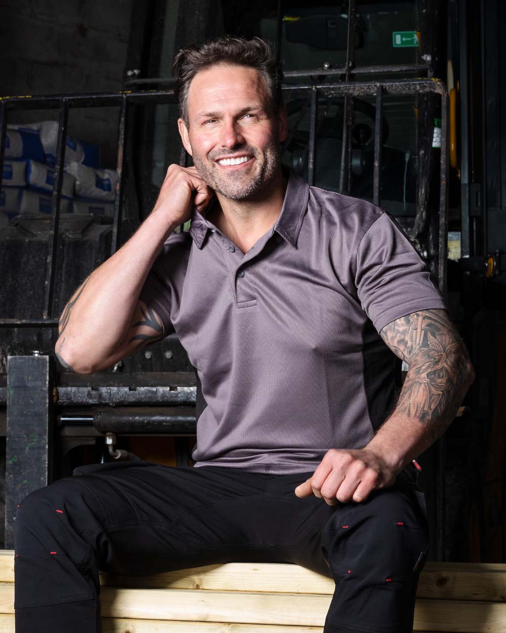 Grey Coloured TuffStuff Elite Polo Shirt On A Warehouse Background