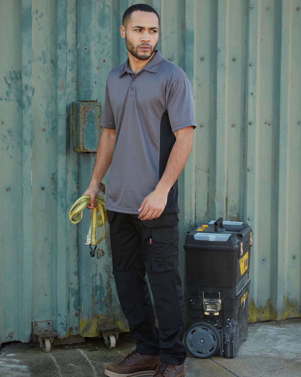Black coloured TuffStuff ProFlex Work Trousers on Work Site background