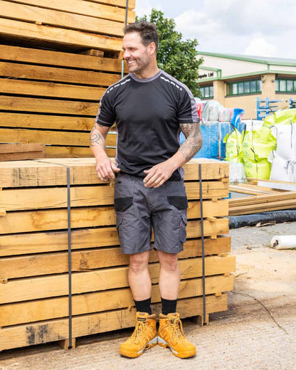 Grey Coloured TuffStuff Elite Work Shorts On A Warehouse Background