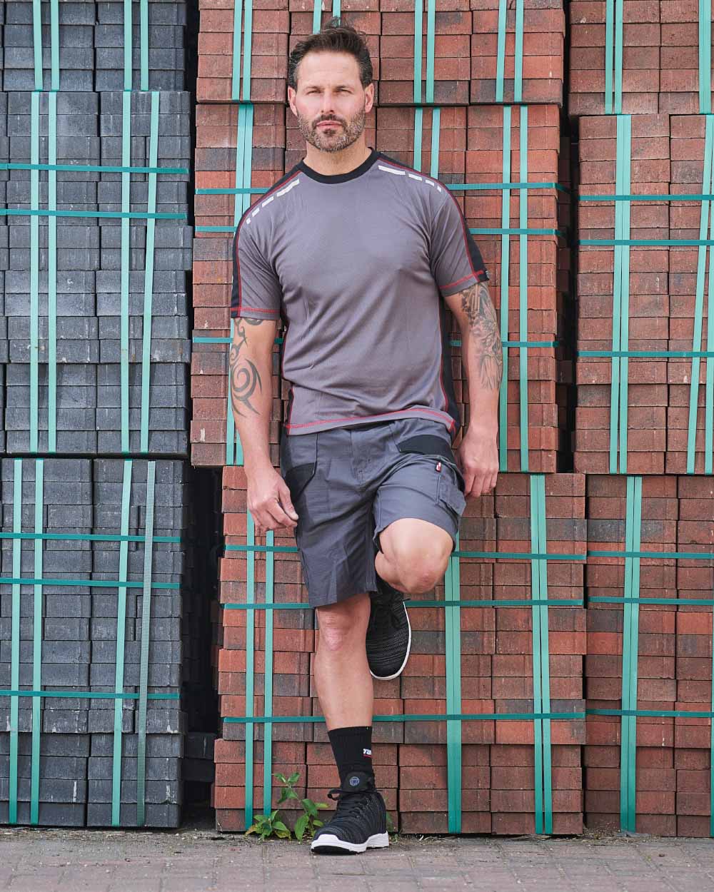 Grey Coloured TuffStuff Elite Work Shorts On A Warehouse Background