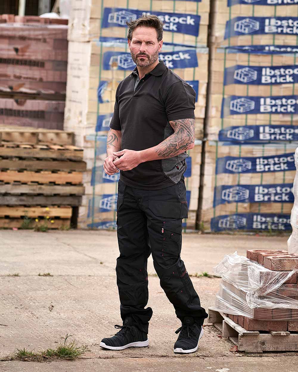 Black Coloured TuffStuff Elite Work Trousers On A Warhouse Background 
