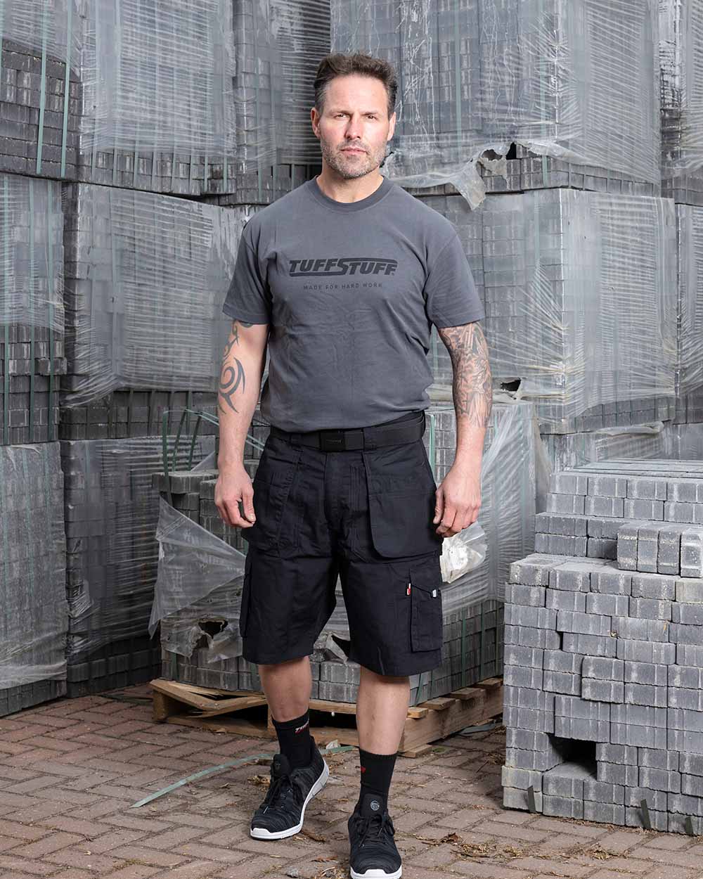Black Coloured TuffStuff Enduro Work Shorts On A Warehouse Background 