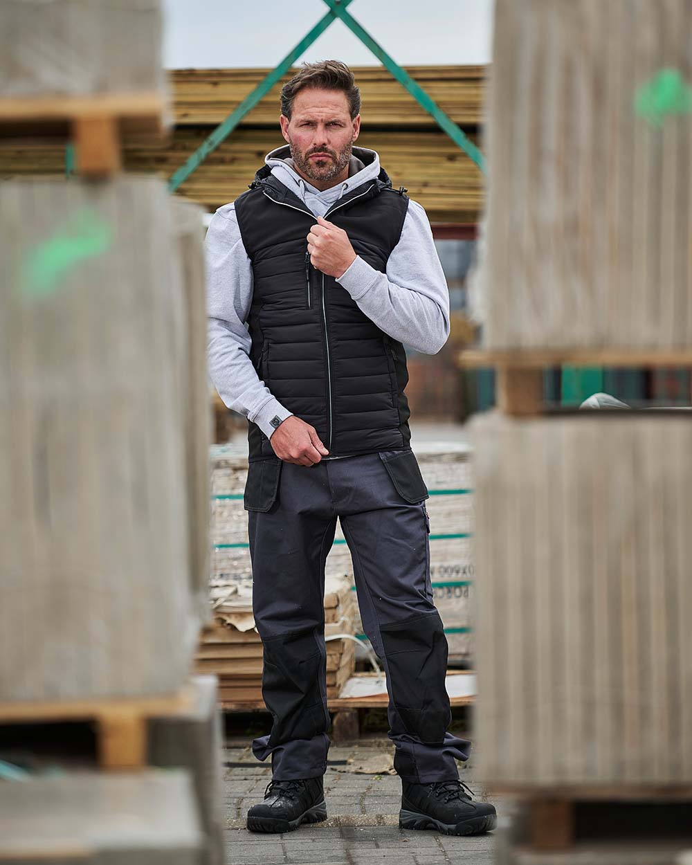 Grey Coloured TuffStuff Excel Work Trousers On A Warehouse Background 