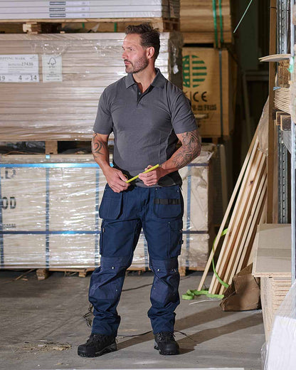 Navy Coloured TuffStuff Extreme Work Trousers On A Warehouse Background 