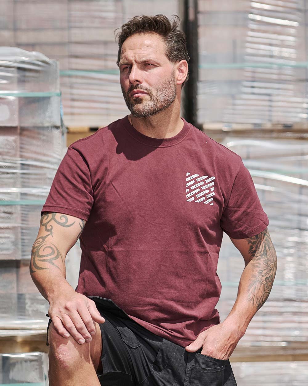Burgundy coloured TuffStuff Logo T-Shirt on construction background 
