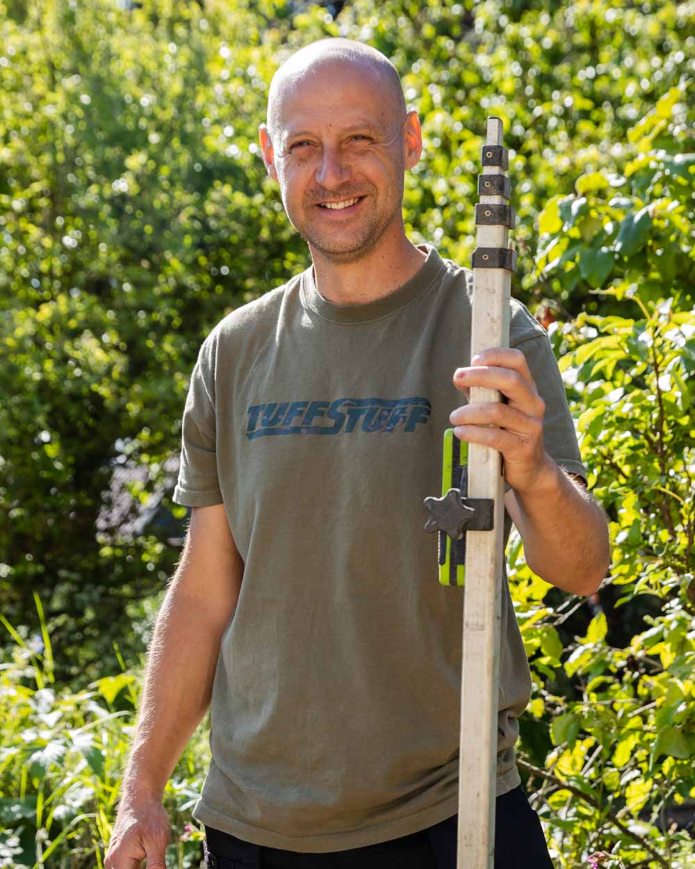 Olive coloured TuffStuff Logo T-Shirt on greenery background 