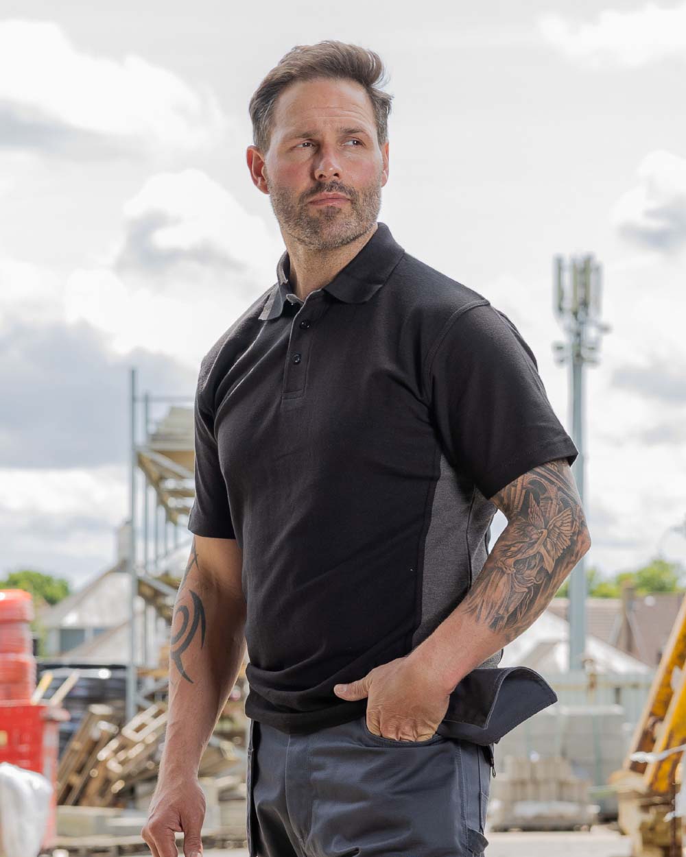 Black Coloured TuffStuff Pro Work Polo Shirt On A Warehouse Background 