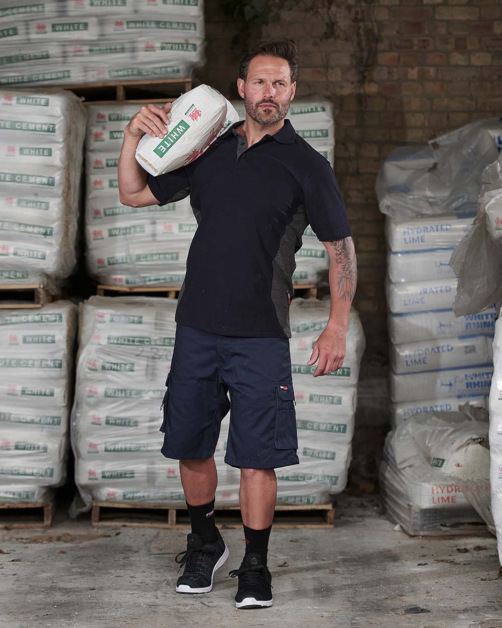 Navy Blue Coloured TuffStuff Pro Work Shorts On A Warehouse Background 