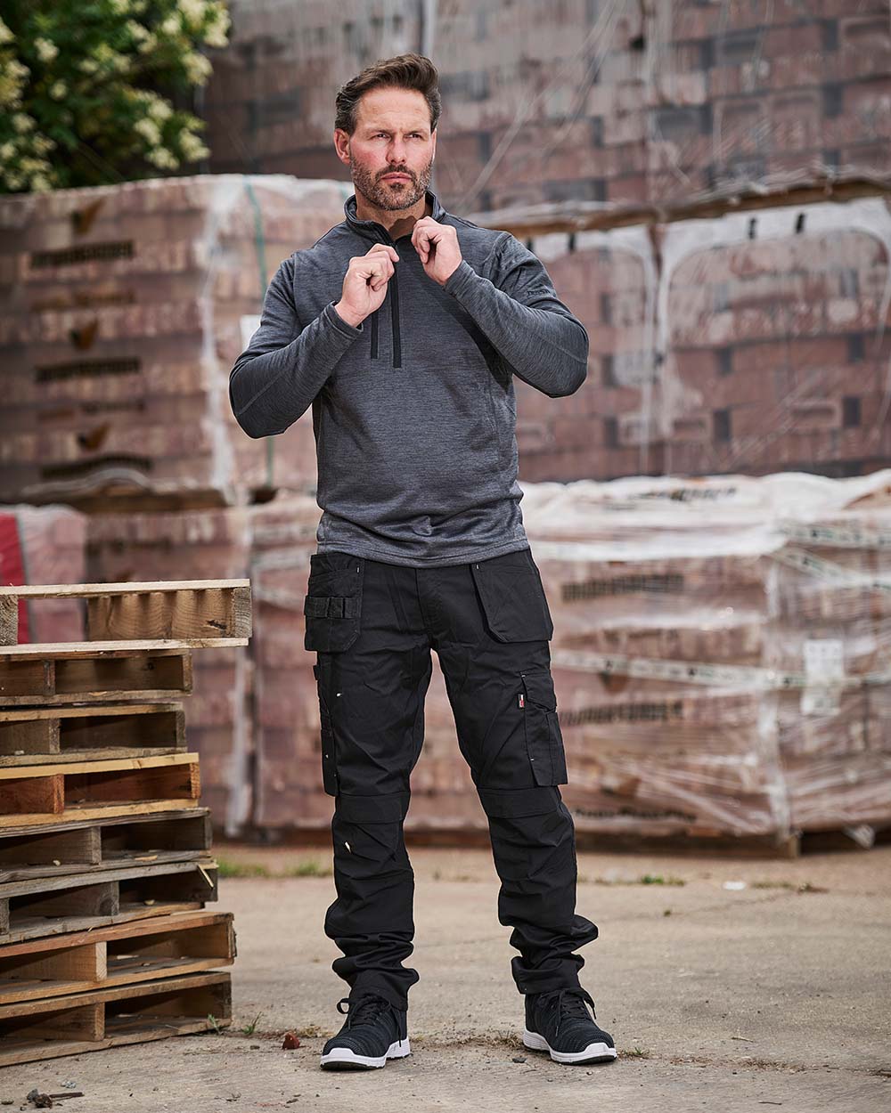 Black coloured TuffStuff ProFlex Work Trousers on Work Site background 