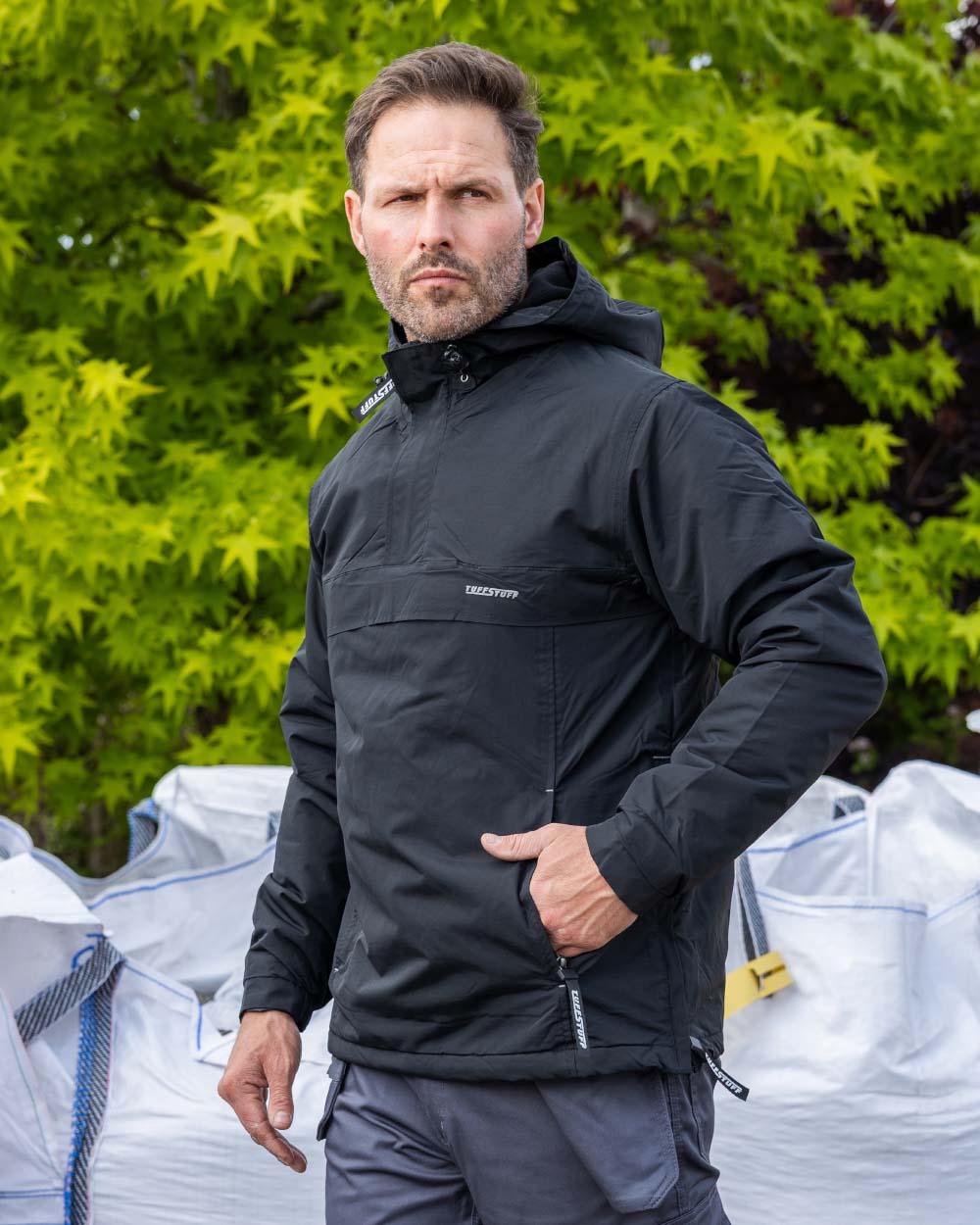 Black Coloured TuffStuff Sutherland Waterproof Windbreaker Smock On A Forest Background 