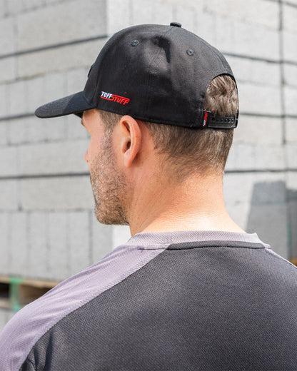 Black coloured TuffStuff Baseball Cap on Model with Construction background 